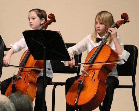 Two students playing their cellos.