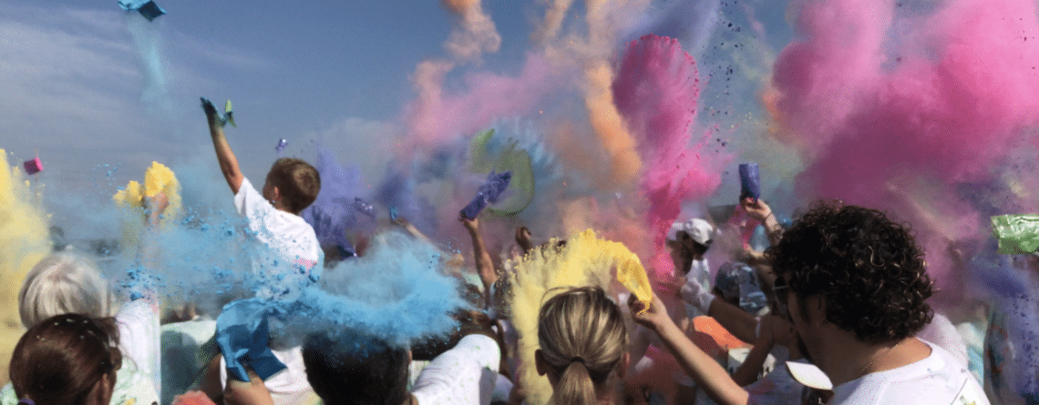 Students and parents throwing color packets during the Color Run color celebration
