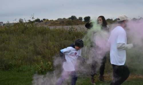 Students and parent being splashed with color during the school's color run