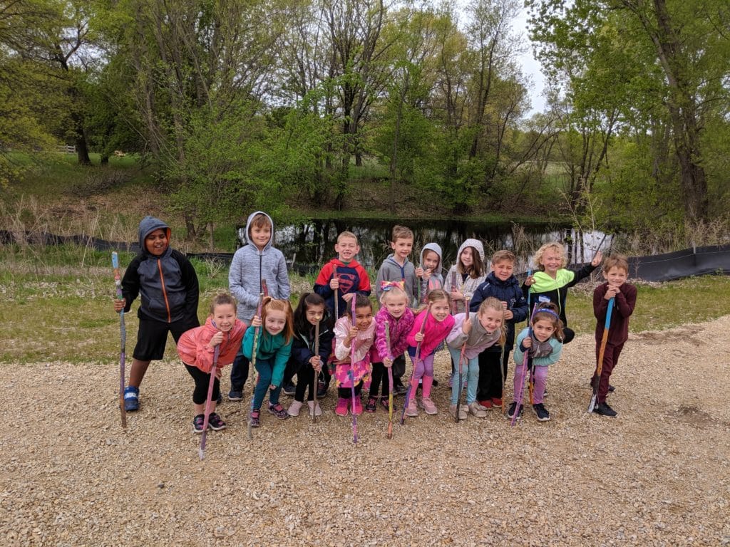 Students on the walking trail with their walking sticks they decorated during class.