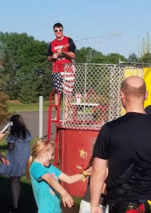 Mr. Slechta on the dunk tank at the Spring Carnival squirting water from a water gun into the crowd.