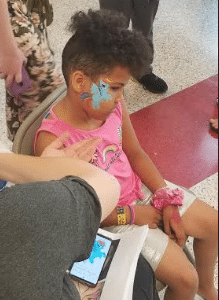 A DaVinci student having her face painted at the Spring Carnival.